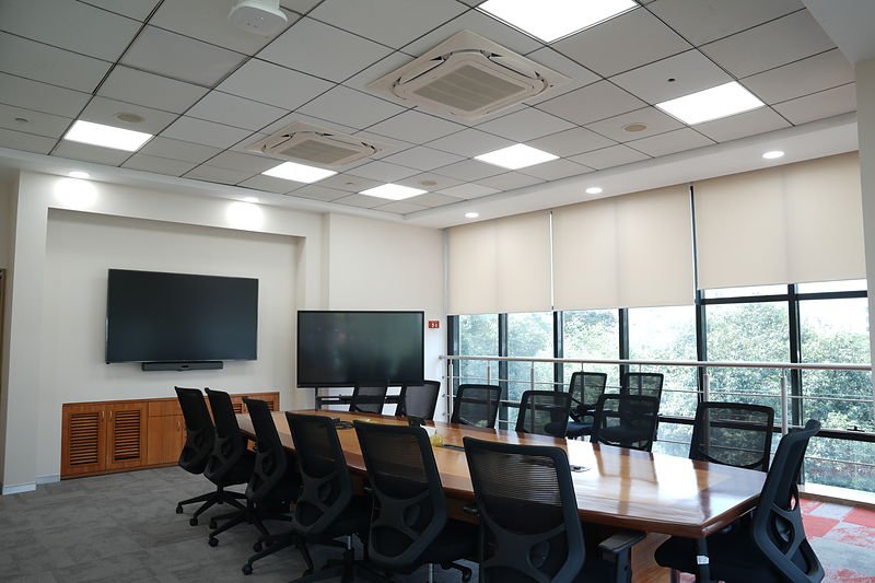 Boardroom seating fourteen, with dual displays and a green outlook.
