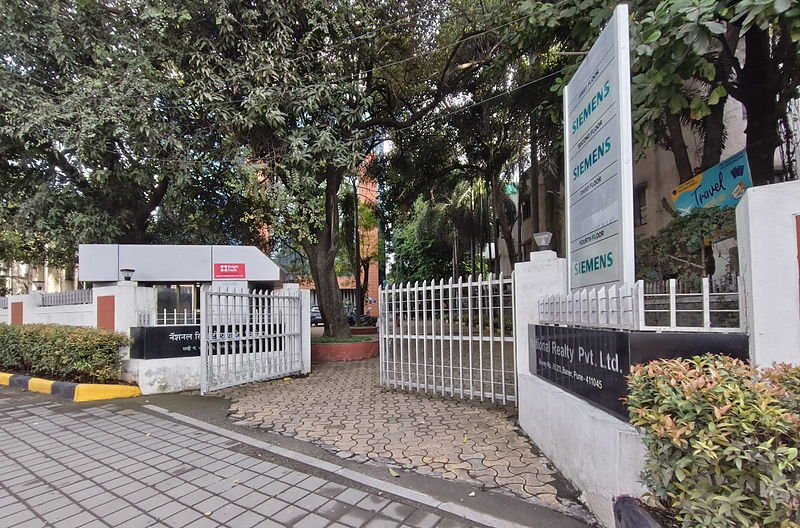 Gated entrance off Baner Road with a manned security cabin and floor directory.